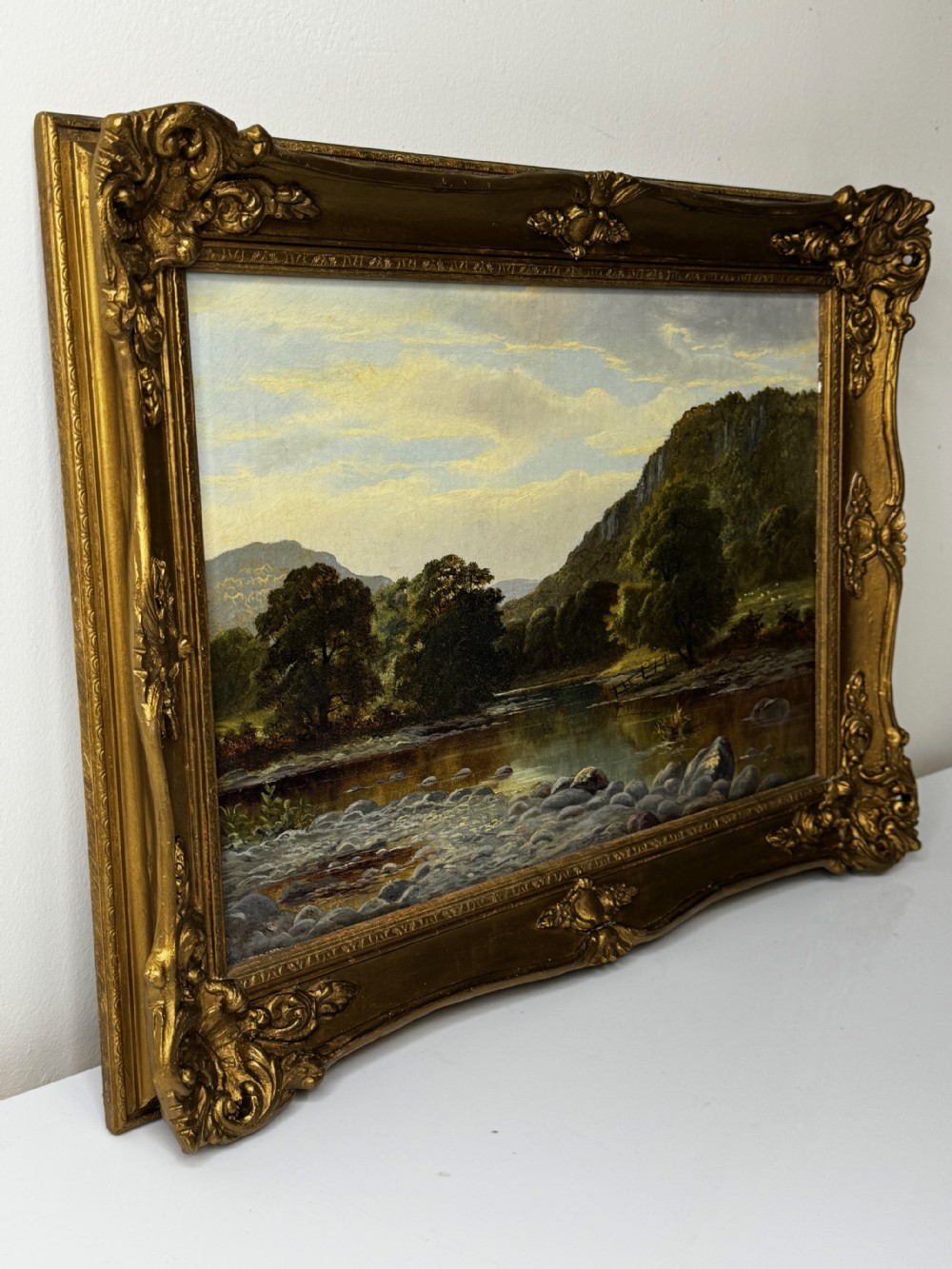 A 19th-century Victorian oil painting depicting a river running through a mountainous Welsh landscape, enclosed in an ornate gold gilt frame. View VIII