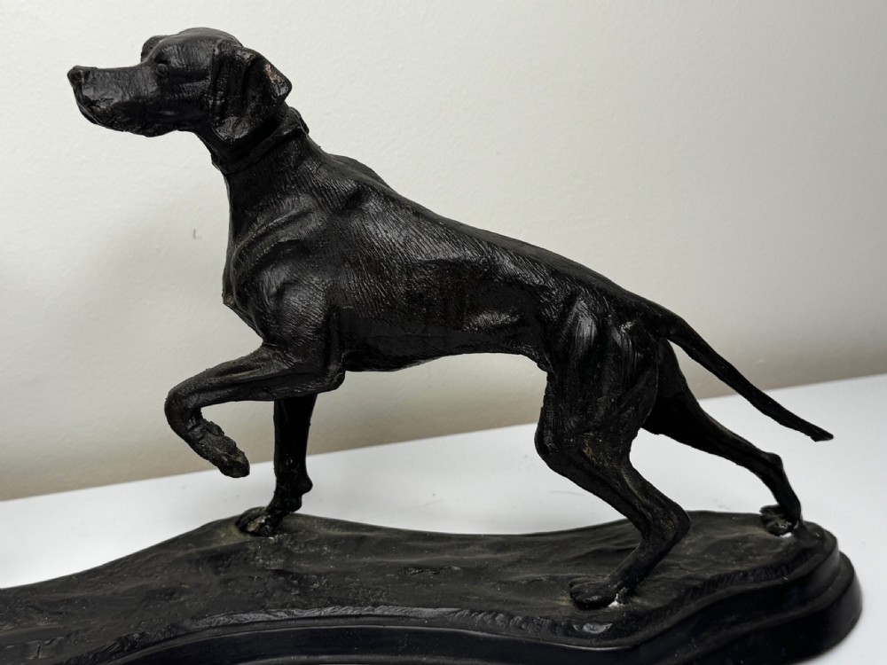 A dark patinated bronze sculpture depicting two hunting hound dogs in active poses on an integral naturalistic base. View III