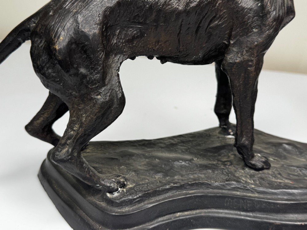 A dark patinated bronze sculpture depicting two hunting hound dogs in active poses on an integral naturalistic base. View XI