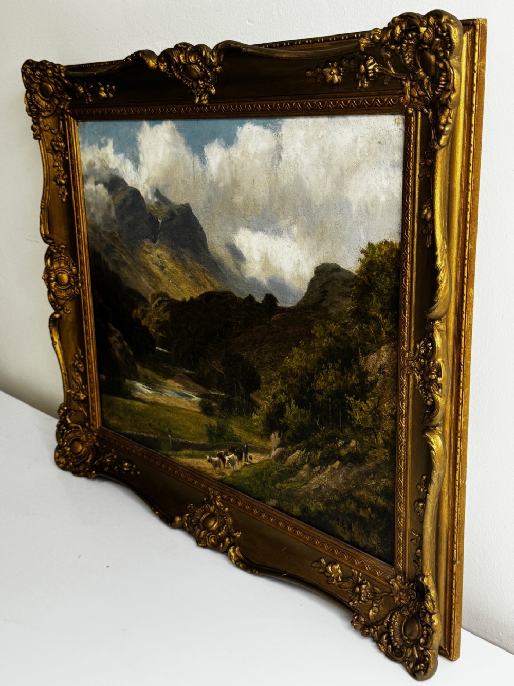 A Victorian landscape oil painting depicting the mountainous Borrowdale valley in the Lake District set within an ornate carved gold gilt frame. View VIII