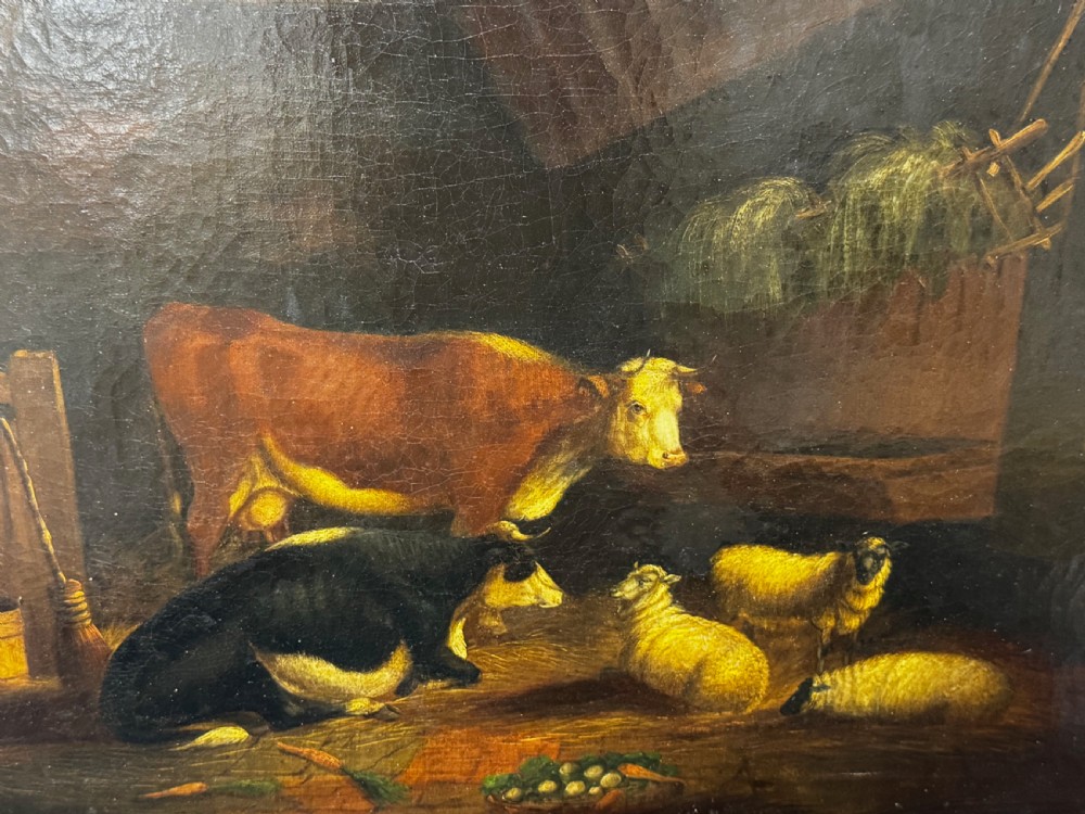 A 19th-century oil painting depicting cattle and sheep resting inside a dimly lit barn beside a hay rack and root vegetables on the floor.