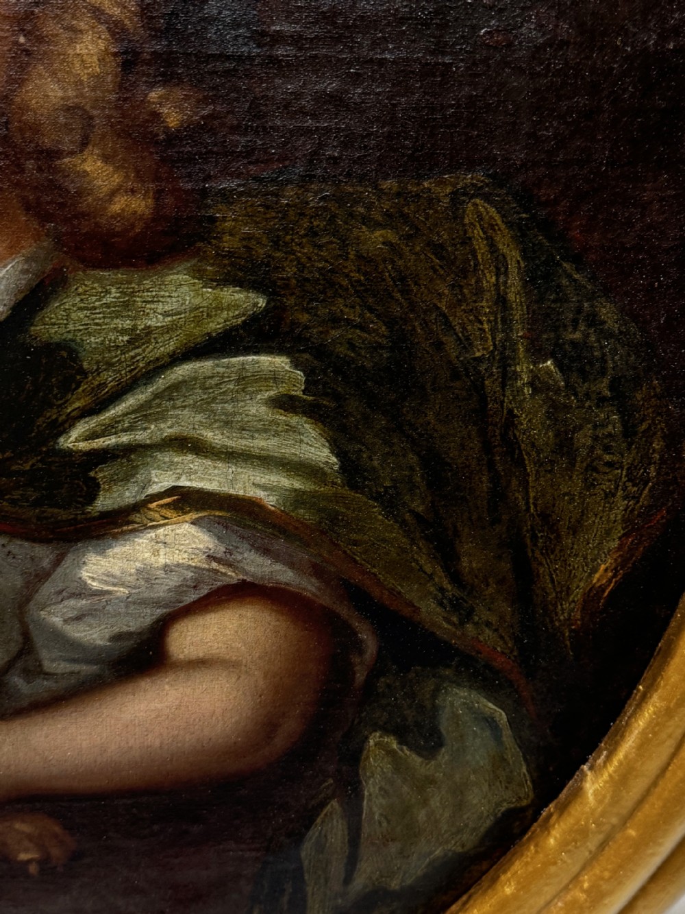 An oval seventeenth-century style oil portrait depicting a young child resting a hand on a King Charles Spaniel puppy, housed in a molded gilt frame. View X