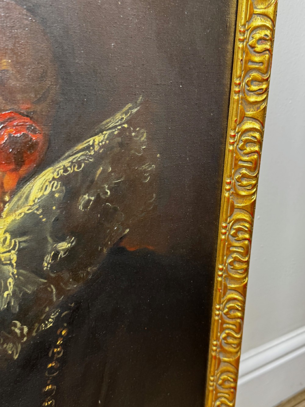 An oil painting depicting a lady in a black gown with a lace ruff collar and gold jewellery, set within an ornate carved giltwood frame. View XX