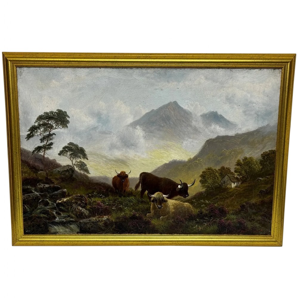 A Victorian oil painting depicting three Highland cattle resting on a hillside in a misty Scottish mountain landscape, enclosed in a rectangular gilt frame.