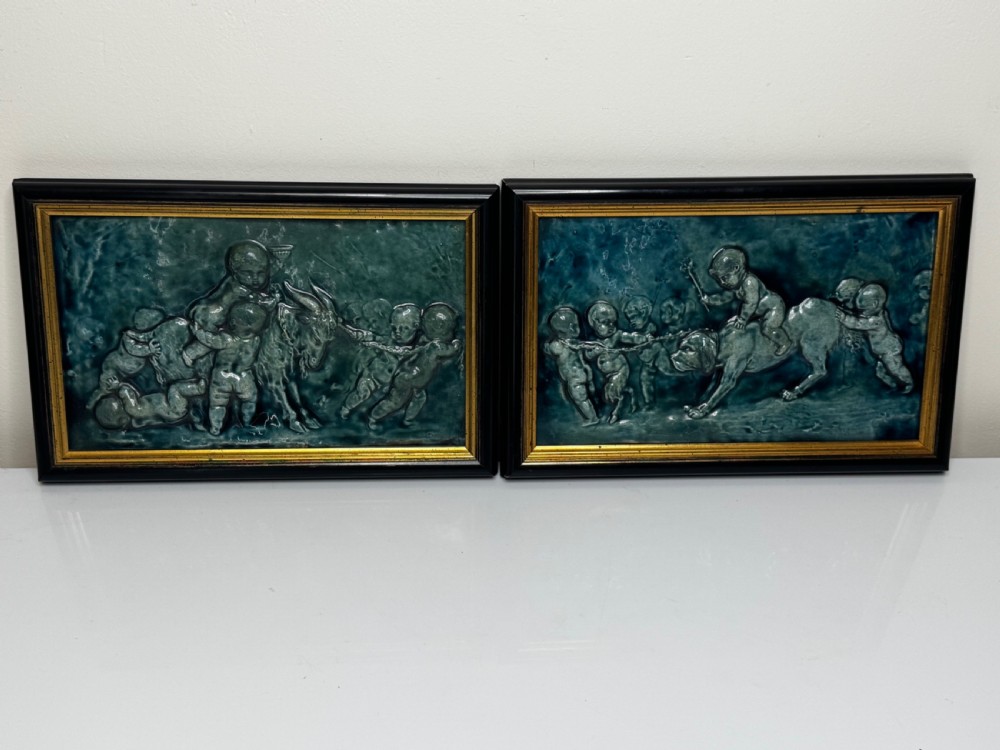 A pair of rectangular Arts and Crafts earthenware relief plaques with turquoise glaze displaying scenes of children with a goat and dog set in ebonised frames. View II