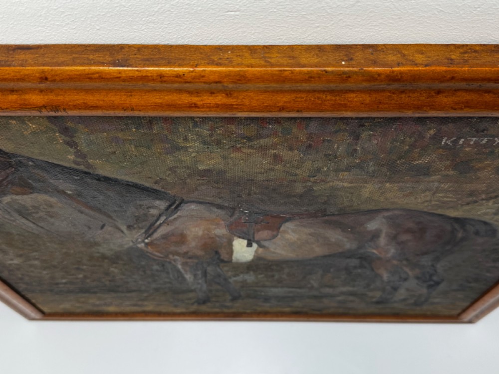 An oil painting framed in wood depicting a saddled brown hunter mare named Kitty standing in profile within a stable setting. View VII