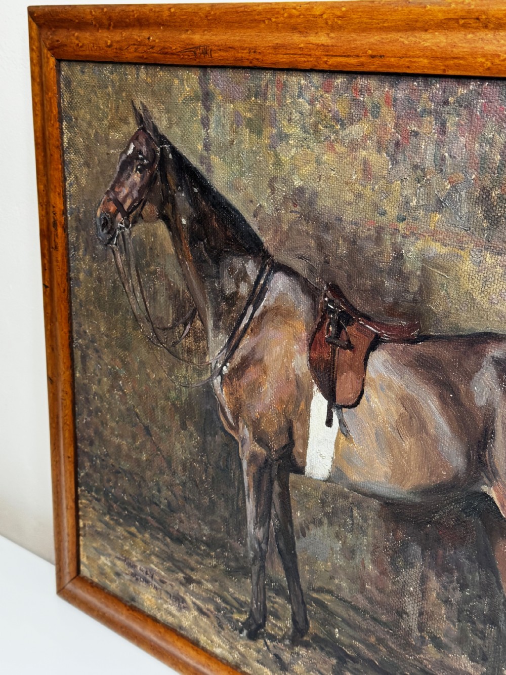 An oil painting framed in wood depicting a saddled brown hunter mare named Kitty standing in profile within a stable setting. View X