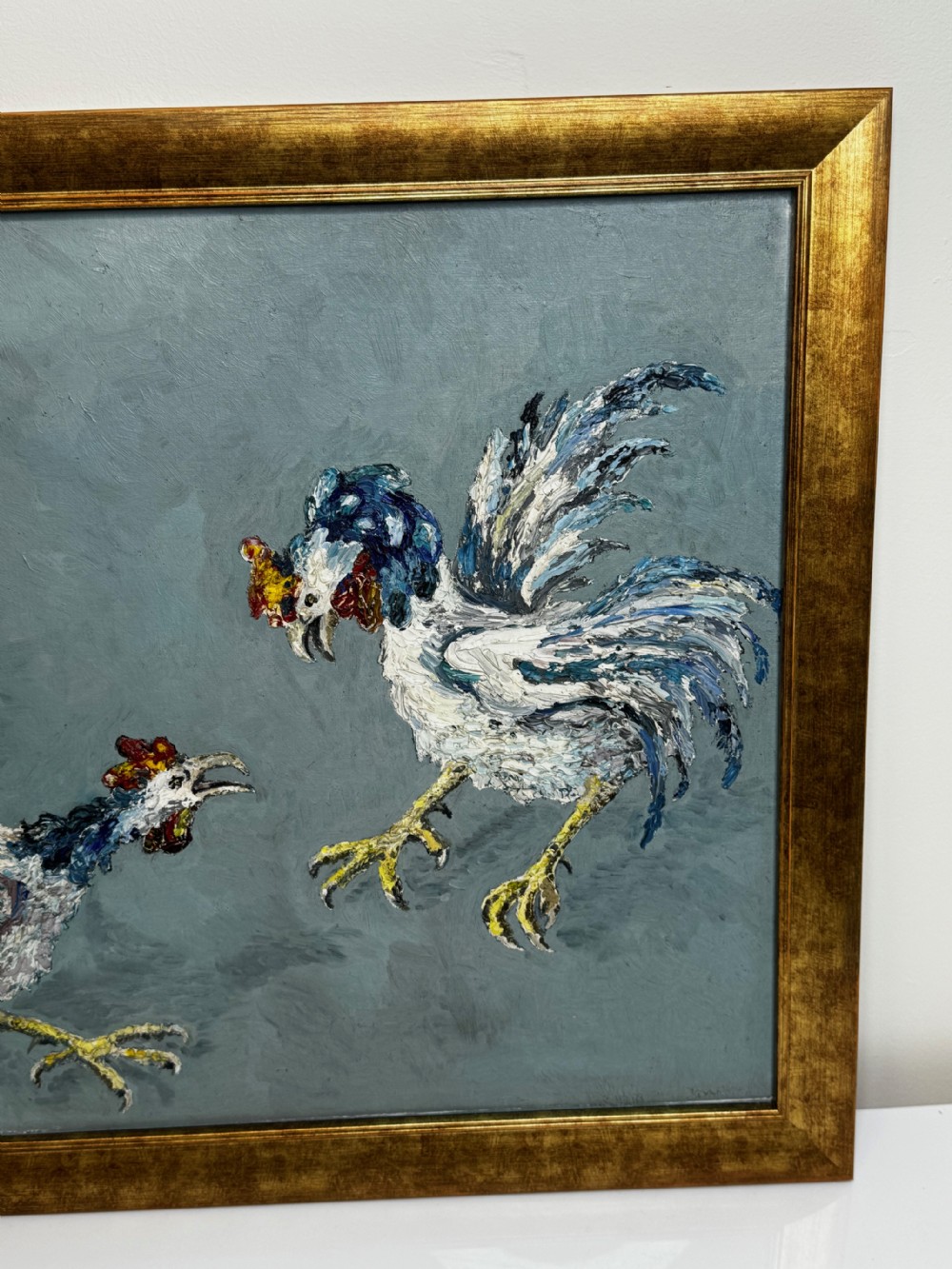 An expressionist impasto oil painting depicting two cockerels in motion against a blue-grey background within a gilt frame. View V