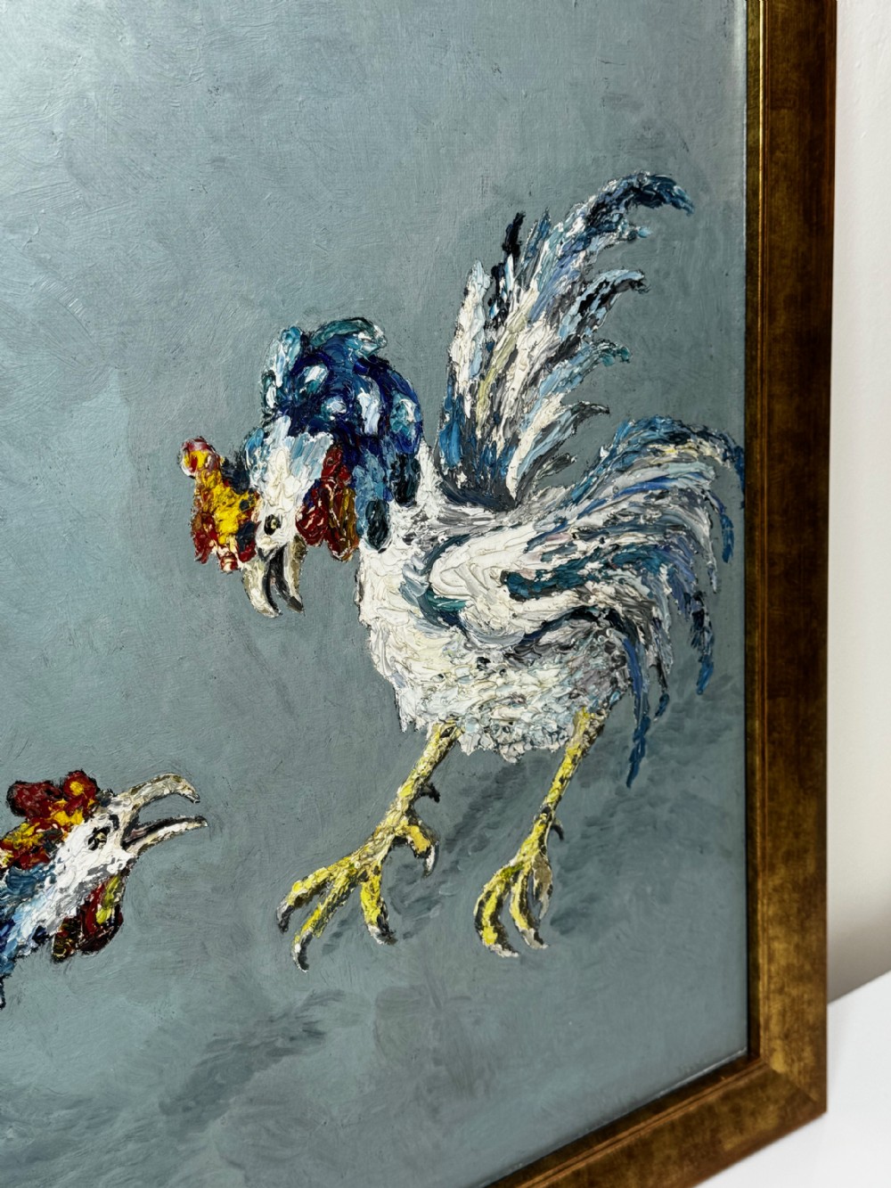 An expressionist impasto oil painting depicting two cockerels in motion against a blue-grey background within a gilt frame. View XII