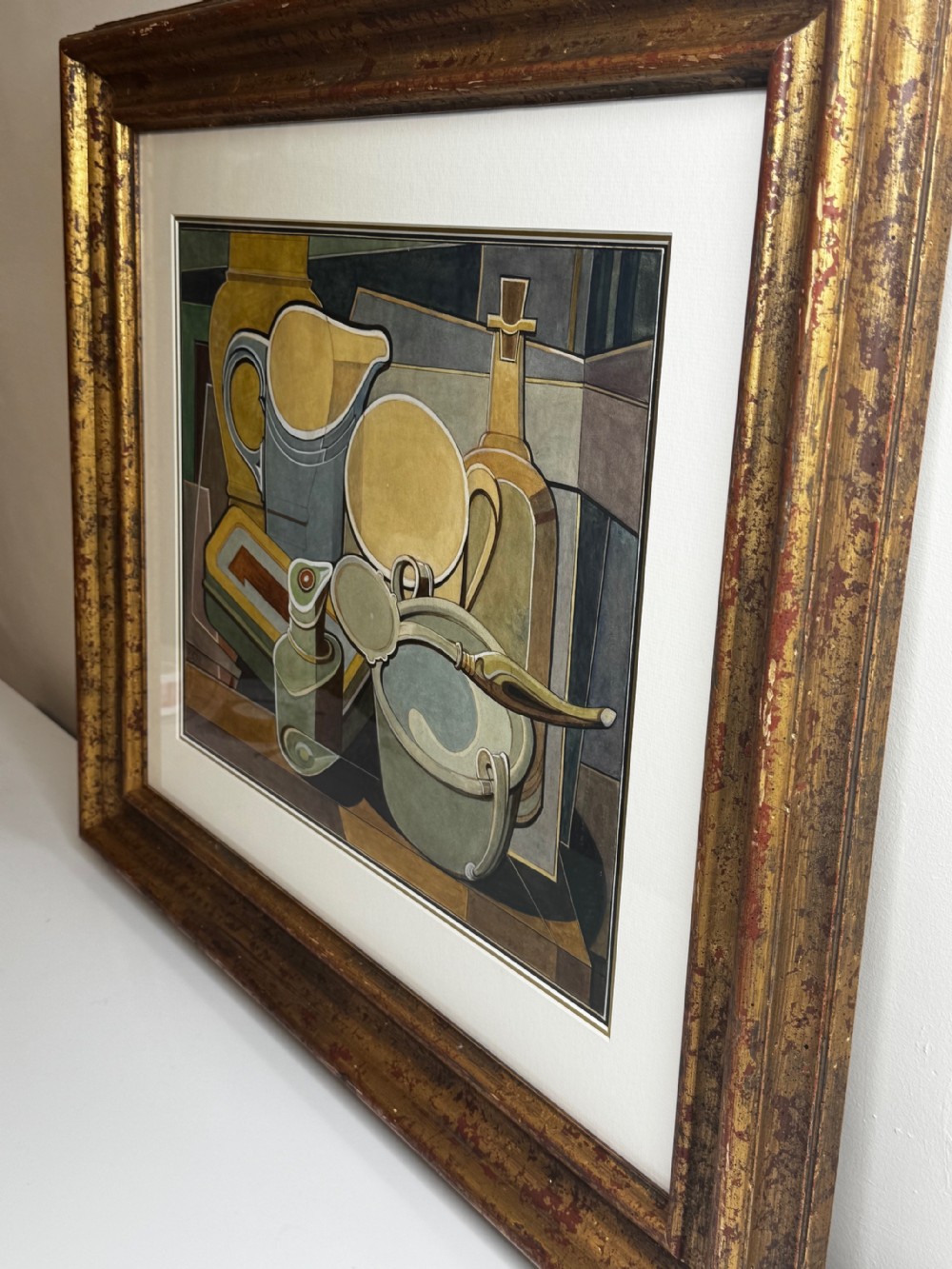 A framed Cubist watercolour still life featuring geometric kitchenware in shades of ochre, grey, and green within a distressed gilt frame. View XV