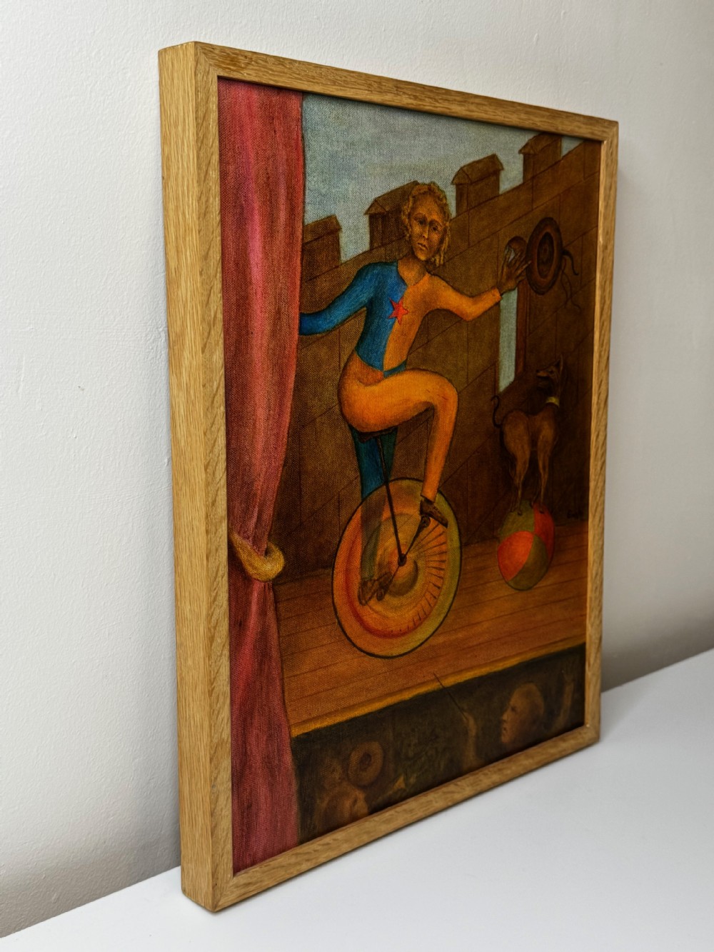 A framed Surrealist oil painting depicting a costume-clad performer on a unicycle next to a dog balancing on a sphere against a stone wall. View VIII