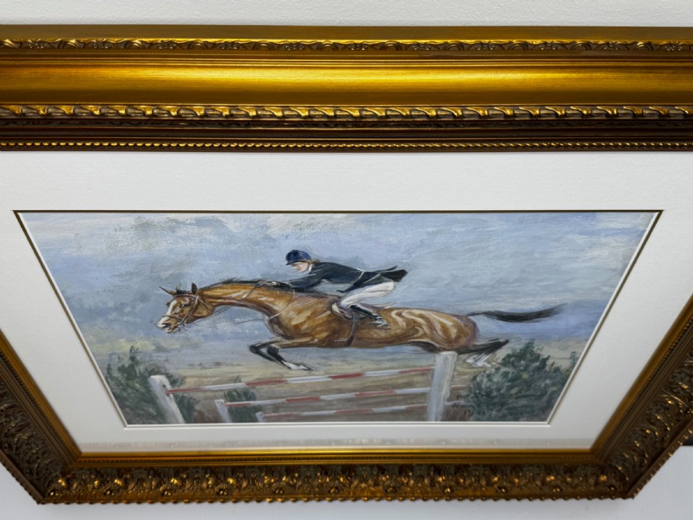 A framed oil painting depicting showjumper Pat Smythe on her horse Finality clearing a fence in 1949. View V