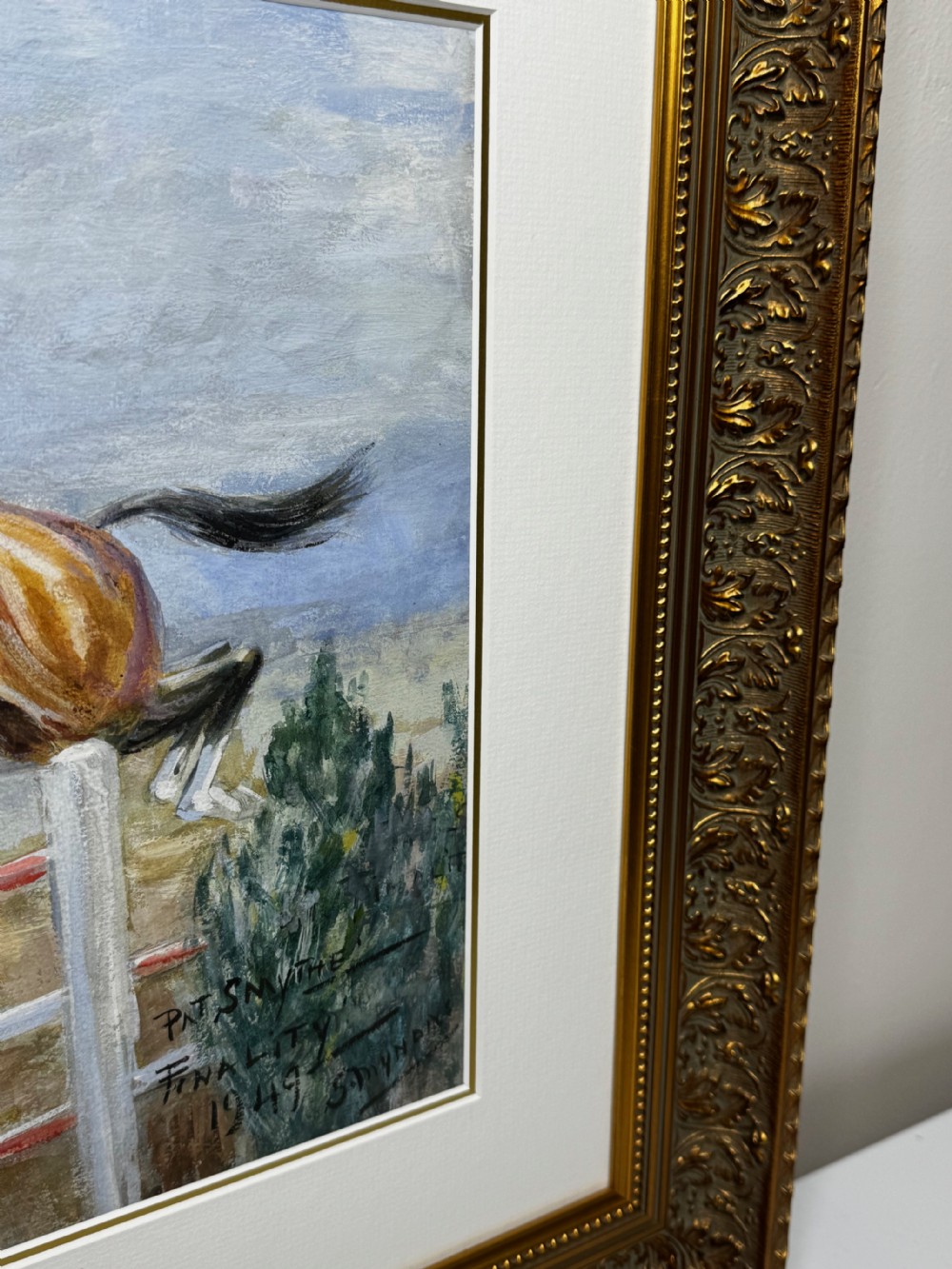 A framed oil painting depicting showjumper Pat Smythe on her horse Finality clearing a fence in 1949. View VI