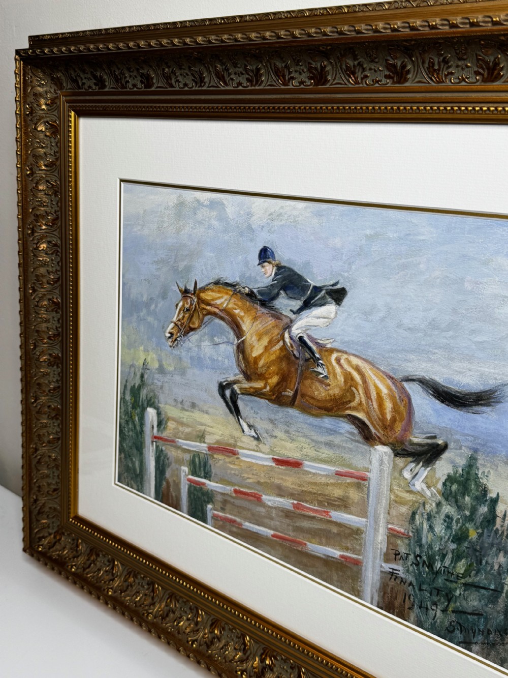 A framed oil painting depicting showjumper Pat Smythe on her horse Finality clearing a fence in 1949. View VII