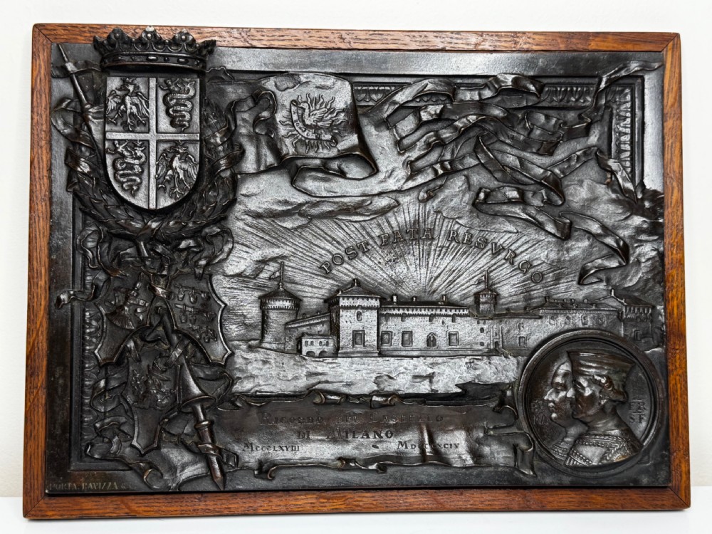 A rectangular dark bronze relief plaque depicting Castello Sforzesco with heraldic coats of arms, mounted inside a wooden frame. View XIV
