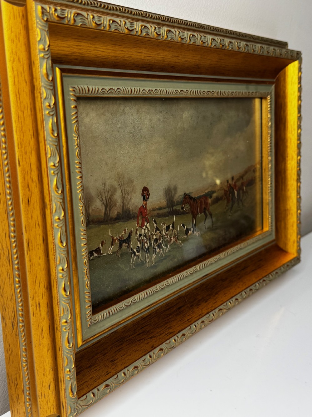 A Victorian oil painting depicting a fox hunting scene with huntsmen on horseback and a pack of hounds in a countryside landscape, housed in a gilded frame. View VII