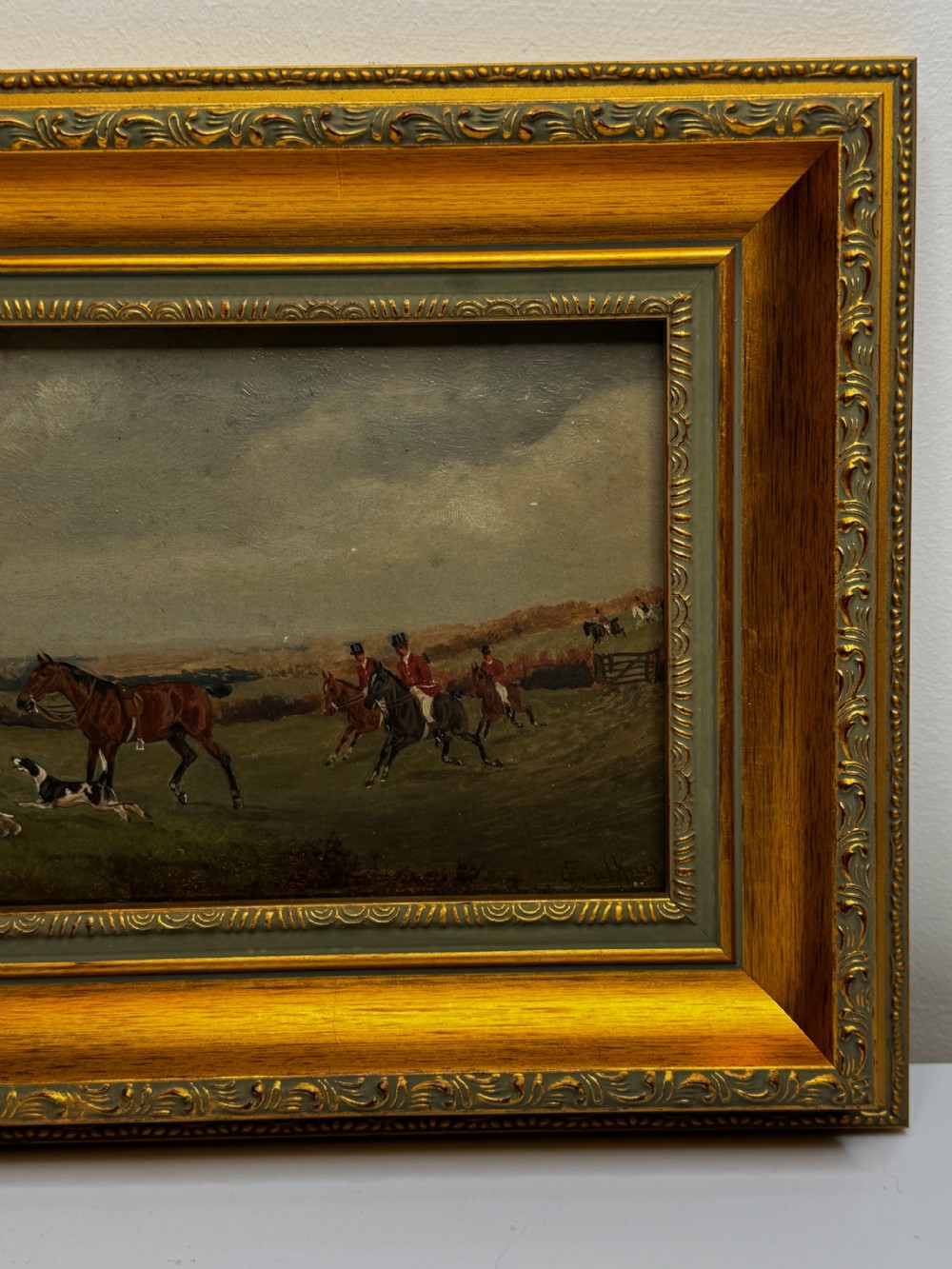 A Victorian oil painting depicting a fox hunting scene with huntsmen on horseback and a pack of hounds in a countryside landscape, housed in a gilded frame. View VIII