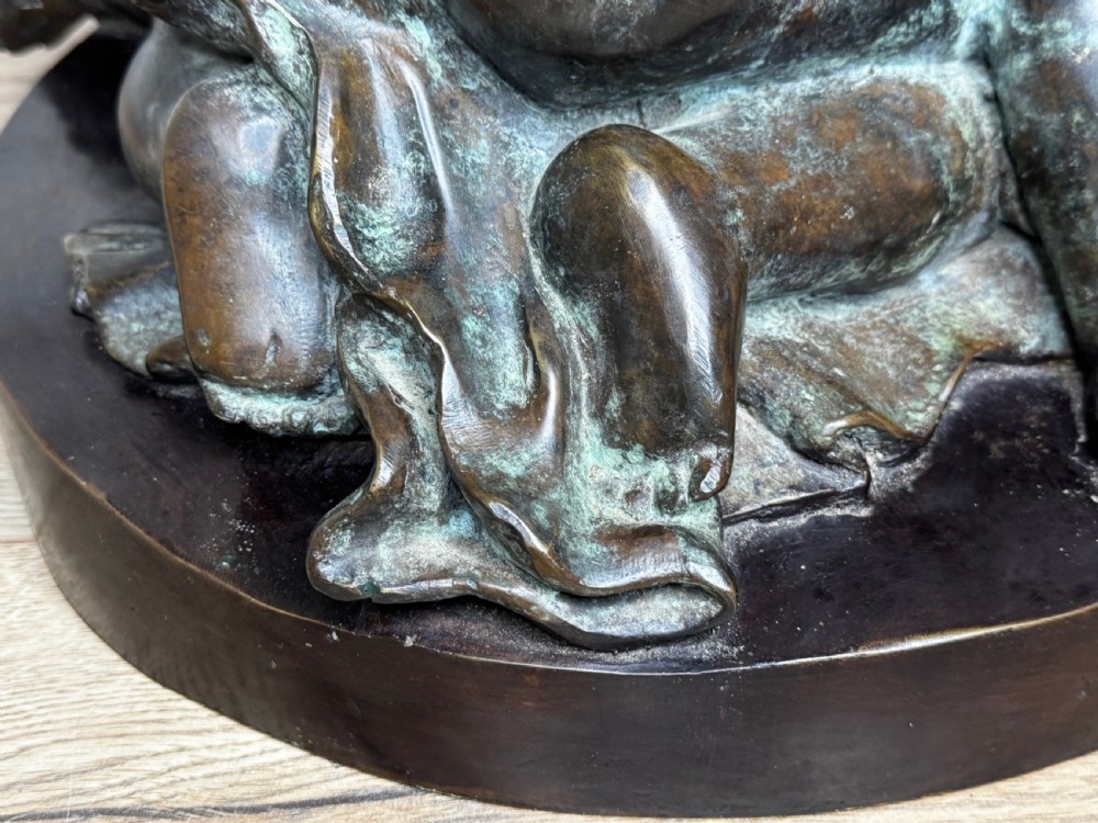 A dark patinated French bronze sculptural group depicting three putti playing, with one child blowing into a conch shell. View VI