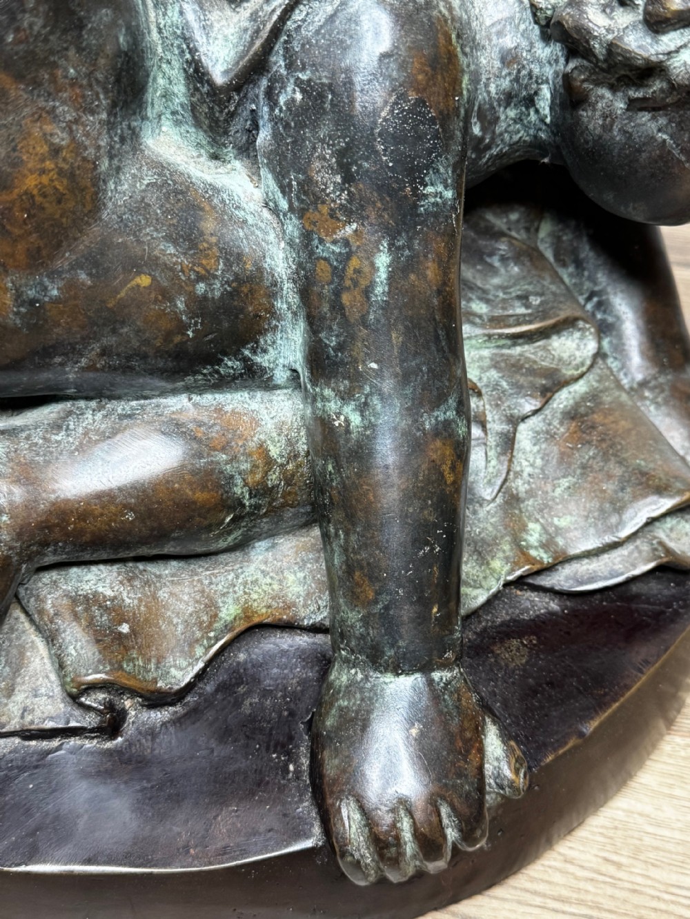 A dark patinated French bronze sculptural group depicting three putti playing, with one child blowing into a conch shell. View VIII