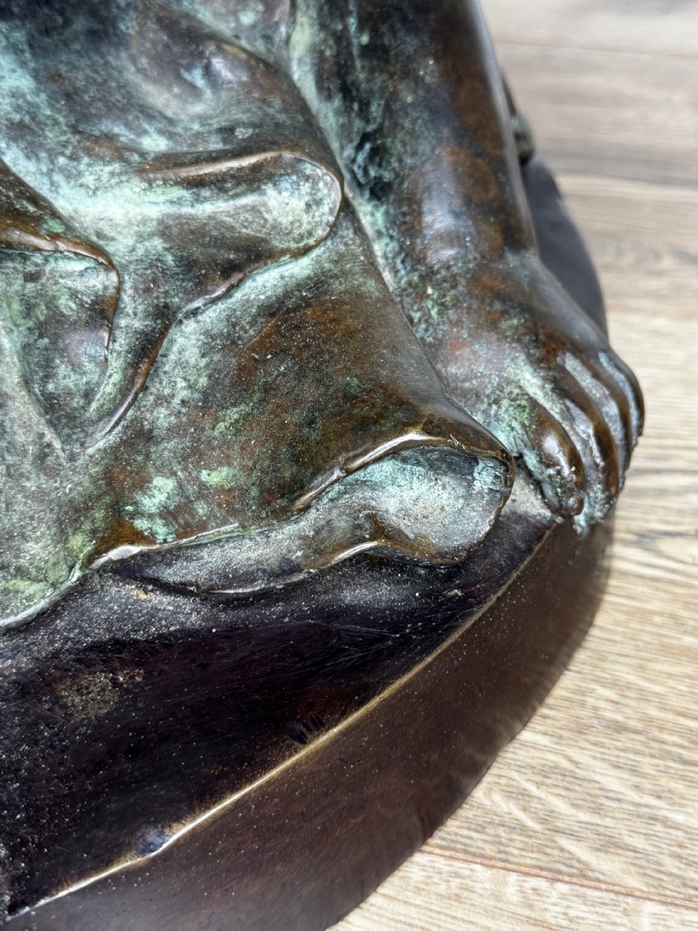 A dark patinated French bronze sculptural group depicting three putti playing, with one child blowing into a conch shell. View X