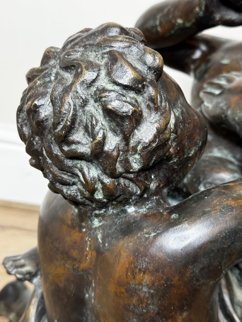 A dark patinated French bronze sculptural group depicting three putti playing, with one child blowing into a conch shell. View XVII