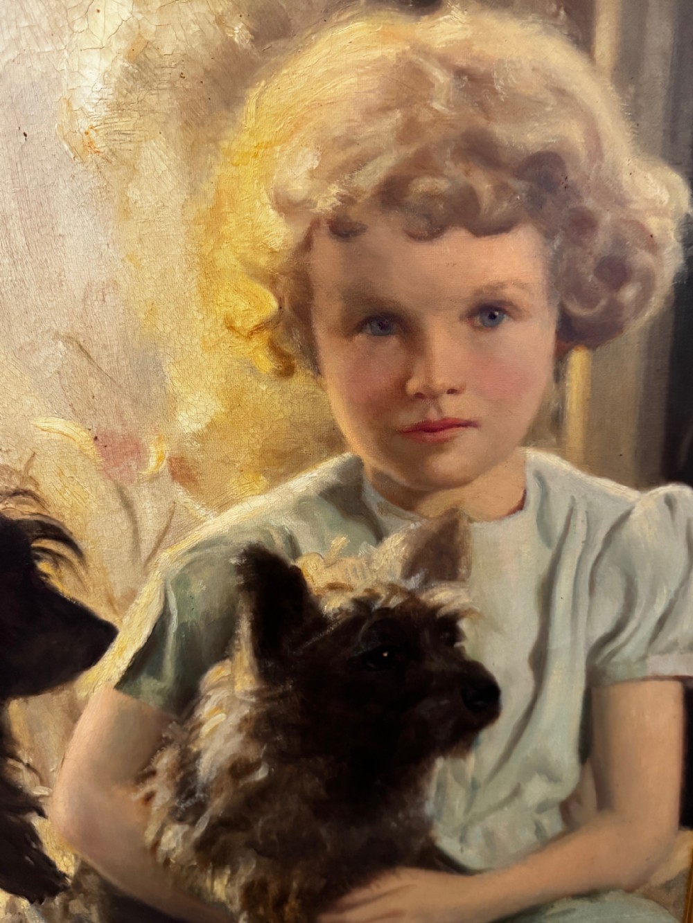 A mid-20th-century oil portrait depicting a young girl with blonde curly hair holding a Cairn Terrier.