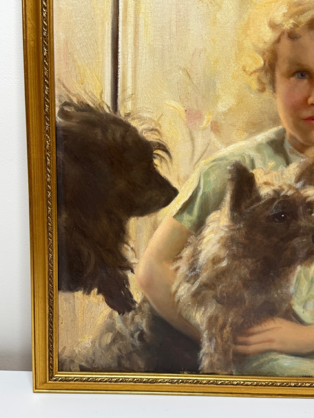 A mid-20th-century oil portrait depicting a young girl with blonde curly hair holding a Cairn Terrier. View XII
