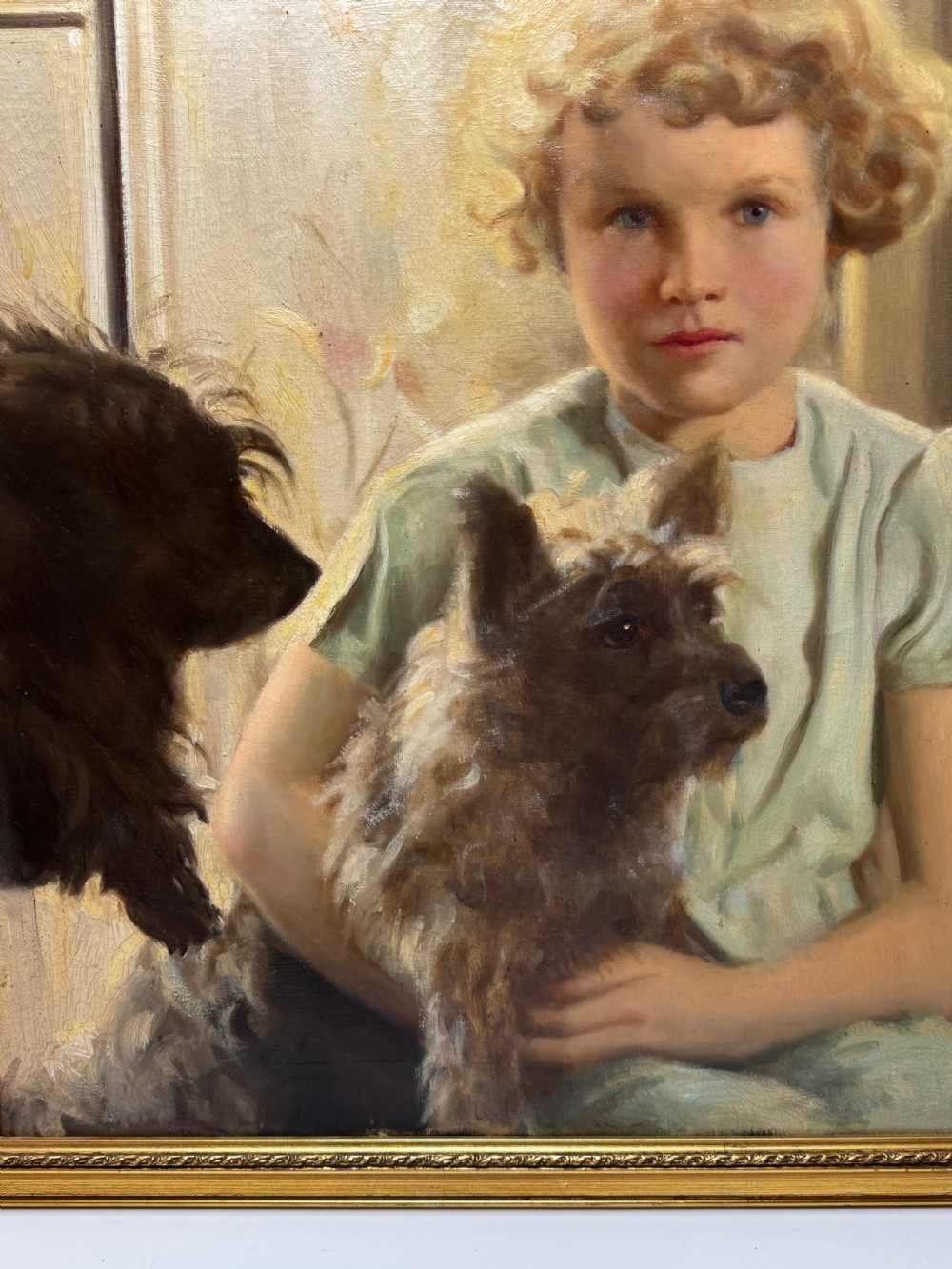 A mid-20th-century oil portrait depicting a young girl with blonde curly hair holding a Cairn Terrier. View XVII