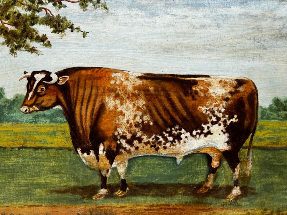 A 19th-century oil painting depicting a brown and white shorthorn bull standing in side profile in a green field, encased in a gilded frame. View IX
