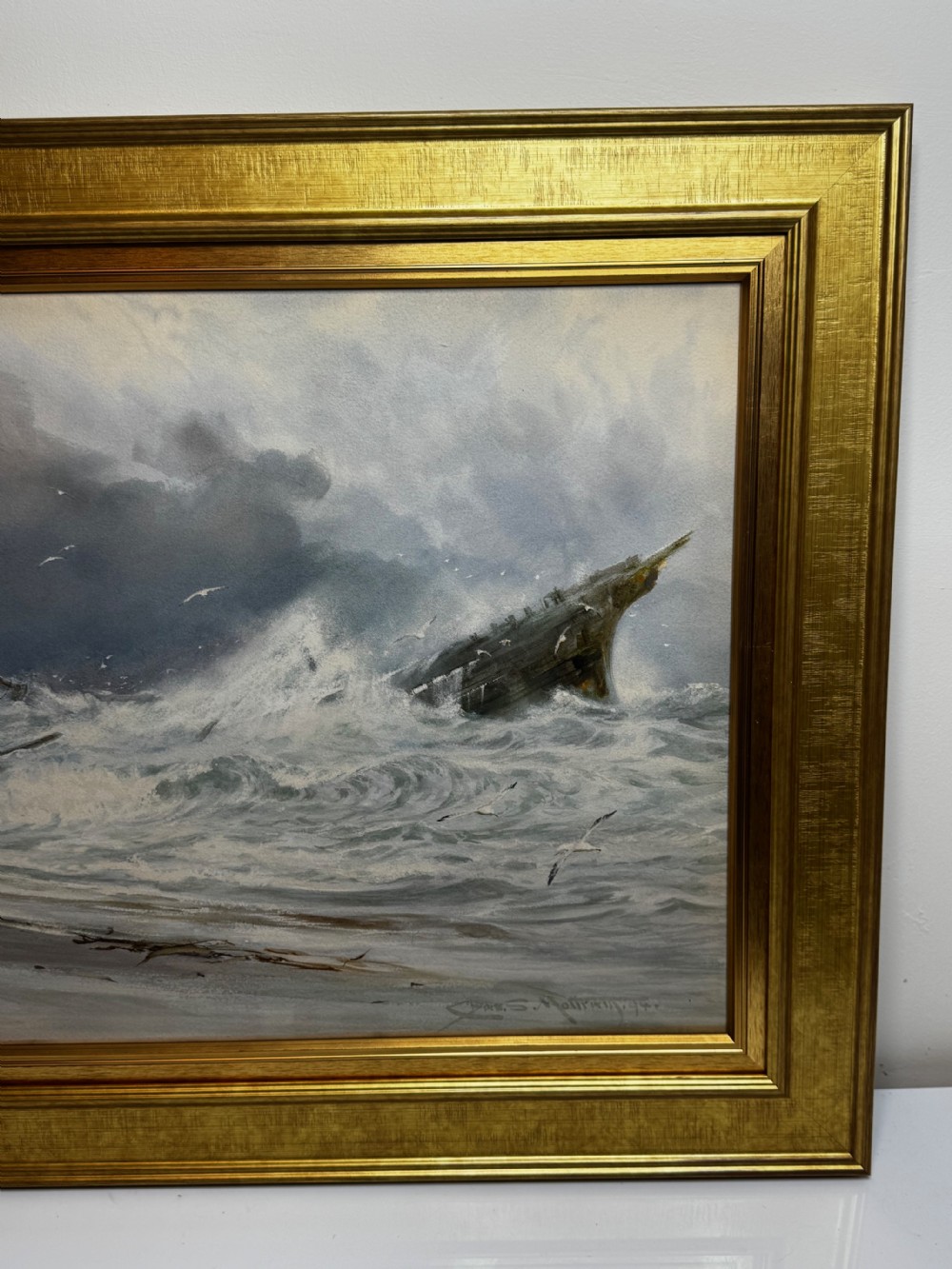 A 19th-century oil painting depicting figures on a shore watching a shipwreck in turbulent seas, set within a molded gilt frame. View VII