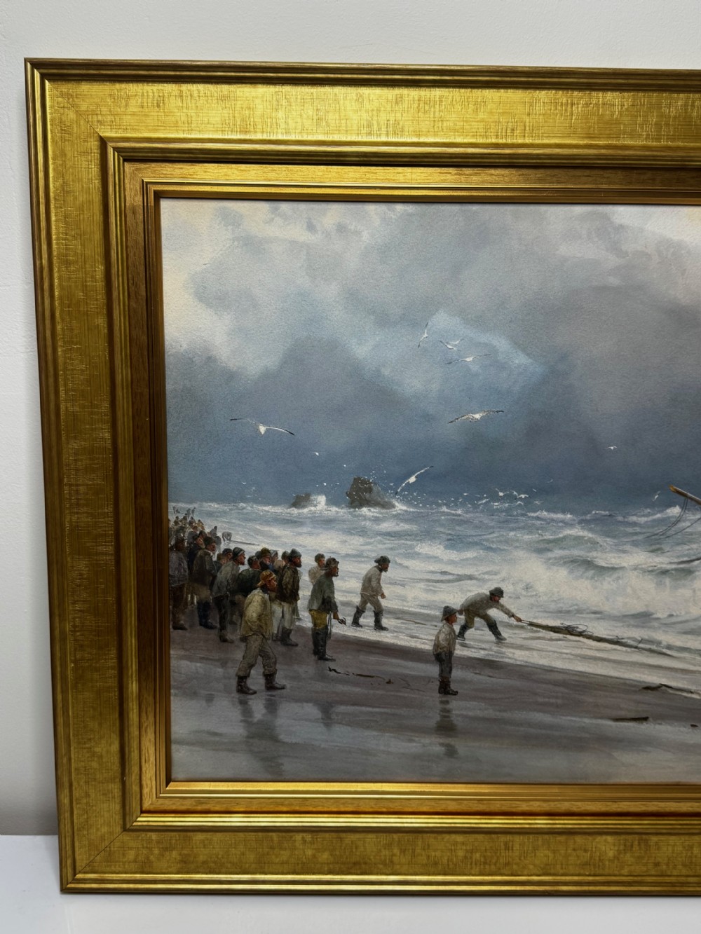 A 19th-century oil painting depicting figures on a shore watching a shipwreck in turbulent seas, set within a molded gilt frame. View VIII