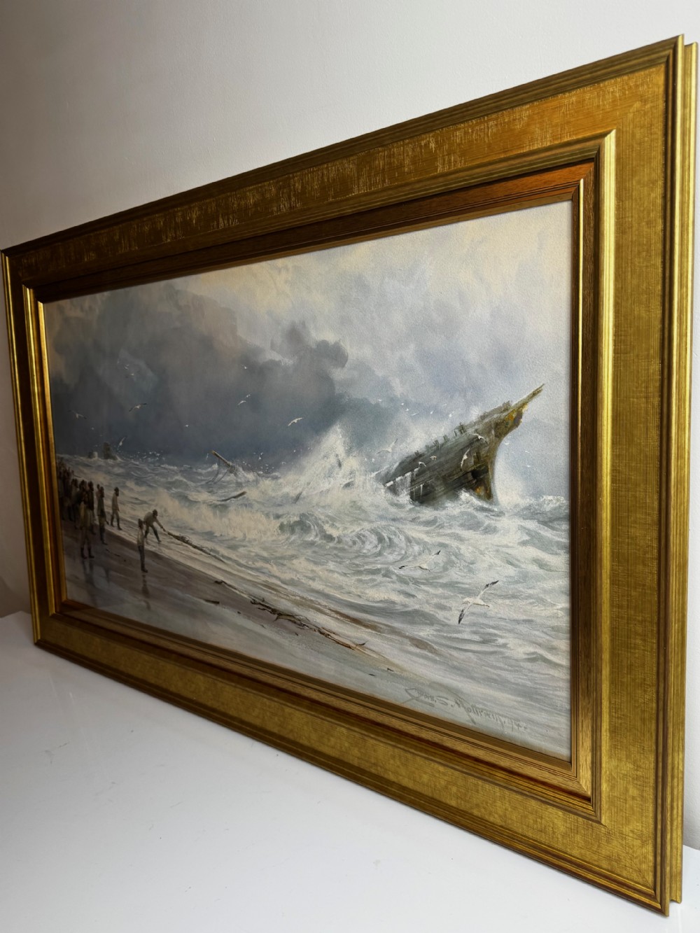 A 19th-century oil painting depicting figures on a shore watching a shipwreck in turbulent seas, set within a molded gilt frame. View XIV