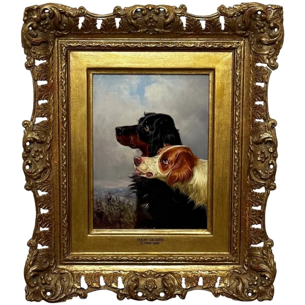An antique Victorian oil painting depicting two setters against a cloudy sky, presented in a carved gold gilt frame.