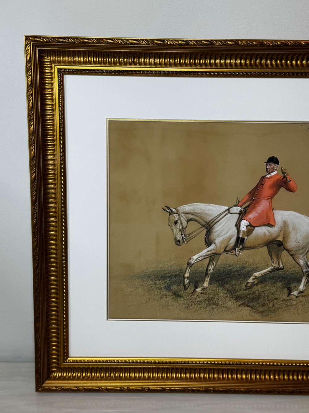 A framed Victorian equestrian painting depicting a huntsman in a red coat riding a grey horse, set within a gilt moulded frame. View V