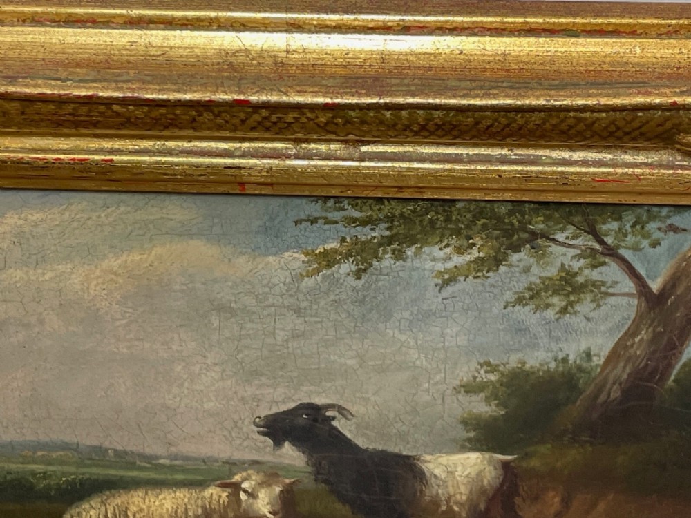 A pair of 19th-century oil paintings in ornate gilt frames depicting sheep, lambs, and goats resting in green pastoral landscapes. View XI