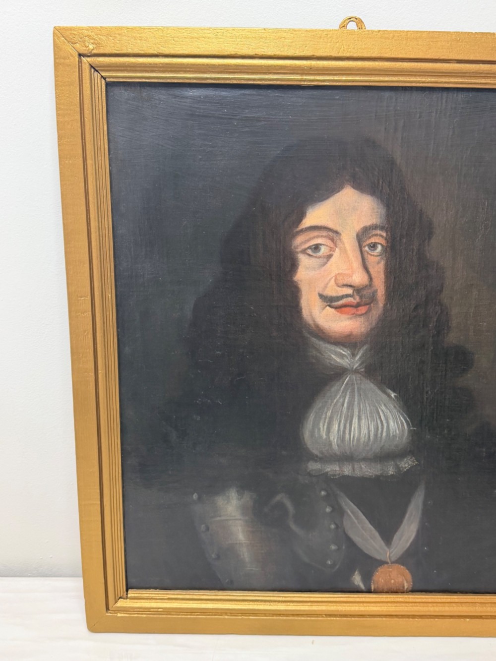 A 19th-century framed oil portrait depicting King Charles II wearing armour, a white lace cravat, and the Order of the Garter medallion against a dark background. View VI