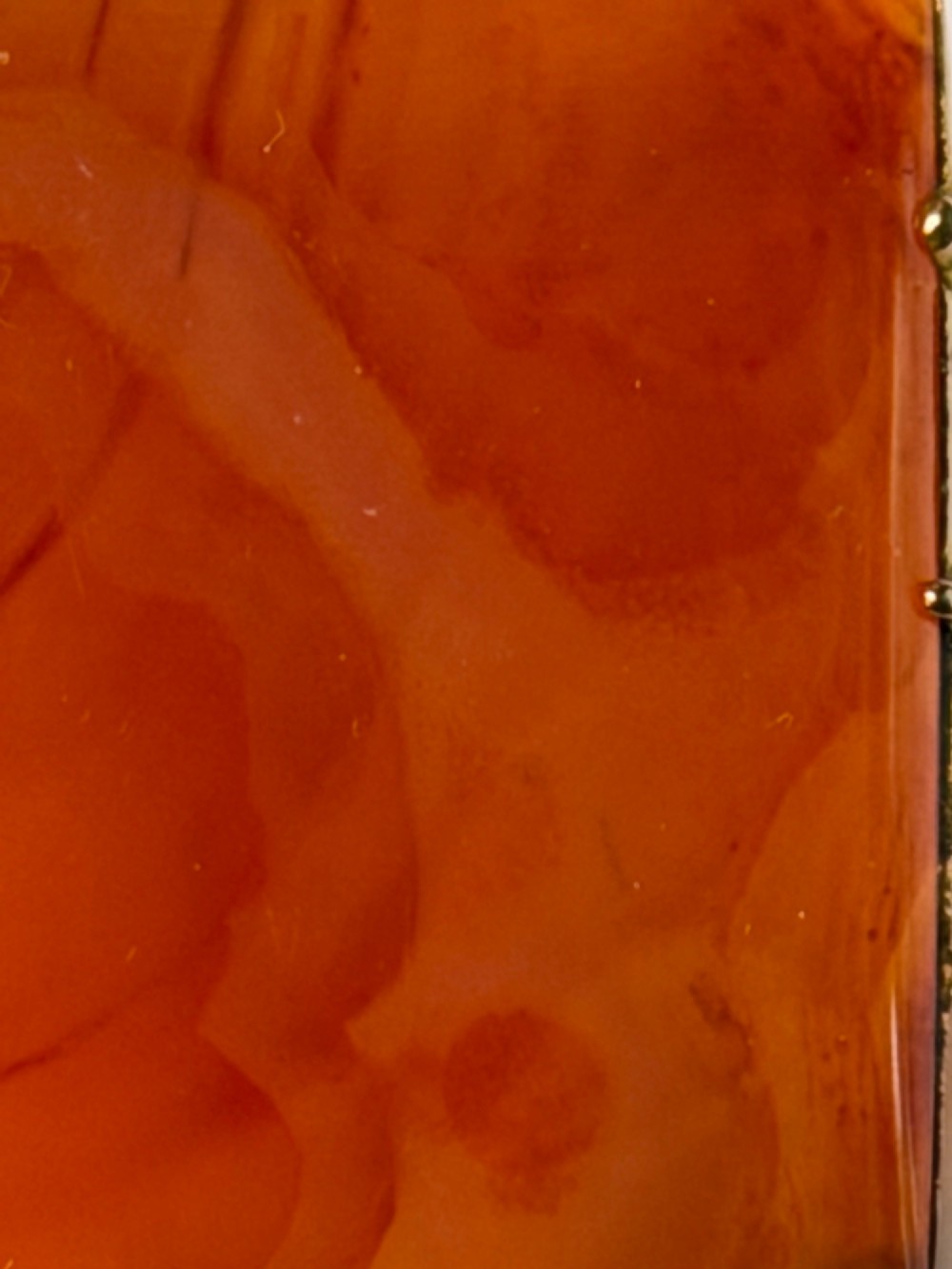 A square-cut translucent warm orange carnelian agate gemstone held in a 9ct gold frame with claw settings. View VIII