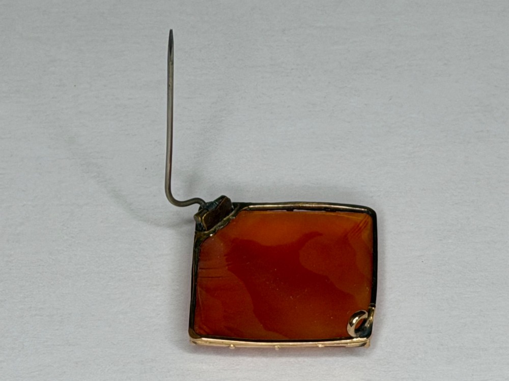 A square-cut translucent warm orange carnelian agate gemstone held in a 9ct gold frame with claw settings. View XII