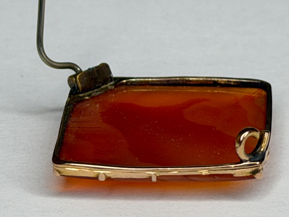 A square-cut translucent warm orange carnelian agate gemstone held in a 9ct gold frame with claw settings. View XIV