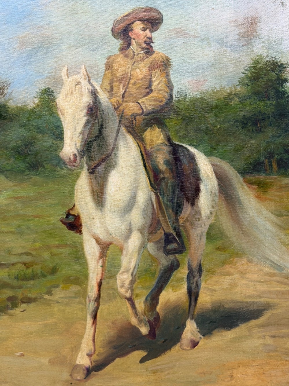 An oil painting depicting a man in a hat and buckskin jacket riding a grey horse along a rural path, set within an ornate gilded wooden frame. View VI