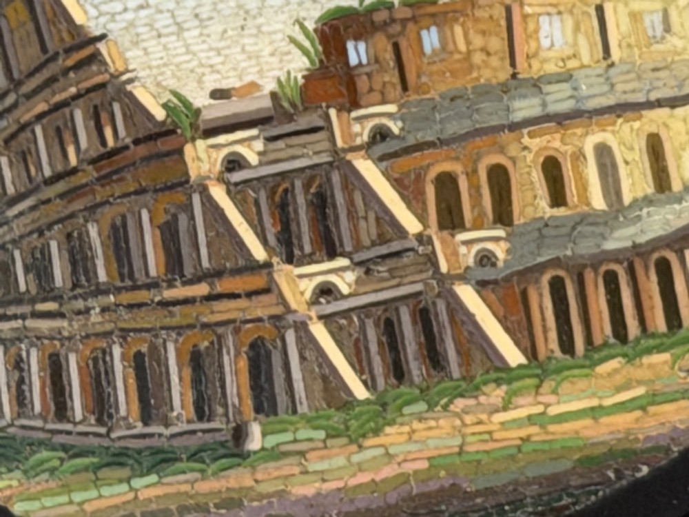 An oval nineteenth-century micromosaic brooch set in a yellow gold bezel depicting the Roman Colosseum against a light blue sky within a black surround. View VI