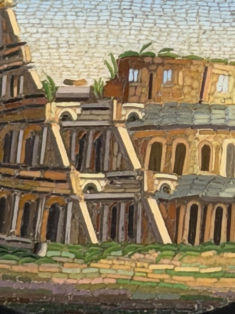An oval nineteenth-century micromosaic brooch set in a yellow gold bezel depicting the Roman Colosseum against a light blue sky within a black surround. View VIII