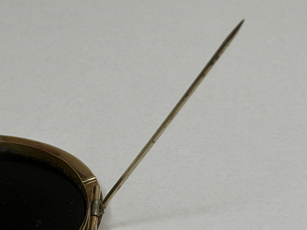 An oval nineteenth-century micromosaic brooch set in a yellow gold bezel depicting the Roman Colosseum against a light blue sky within a black surround. View XI