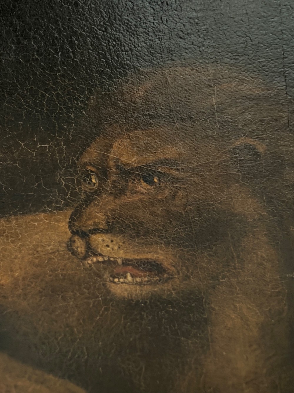 A framed Victorian oil painting depicting Daniel in a red robe seated inside a dark cavern surrounded by lions. View IV
