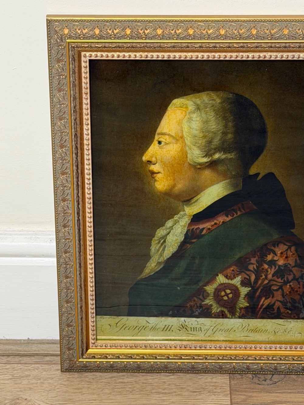 An 18th-century reverse glass mezzotint profile portrait of King George III housed within a decorative gilt frame. View III
