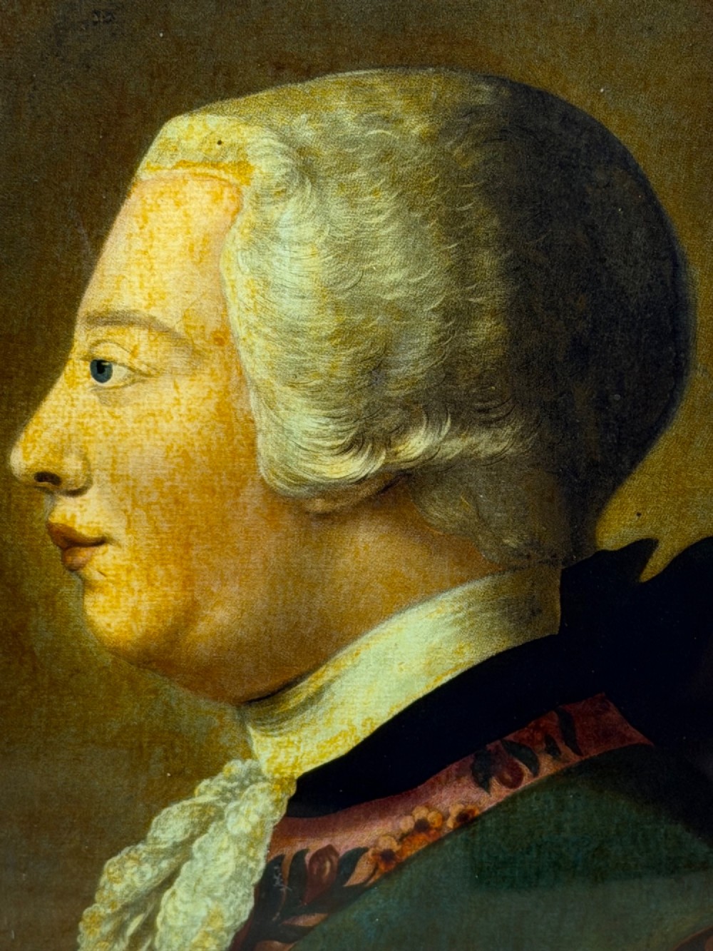 An 18th-century reverse glass mezzotint profile portrait of King George III housed within a decorative gilt frame. View X