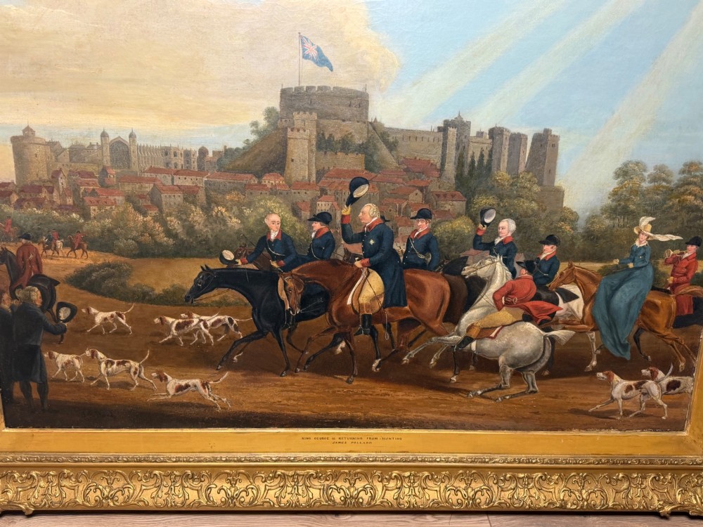 An antique oil painting on canvas depicting King George and hunters on horseback with hounds before Windsor Castle, housed in an ornate carved gilt frame. View II
