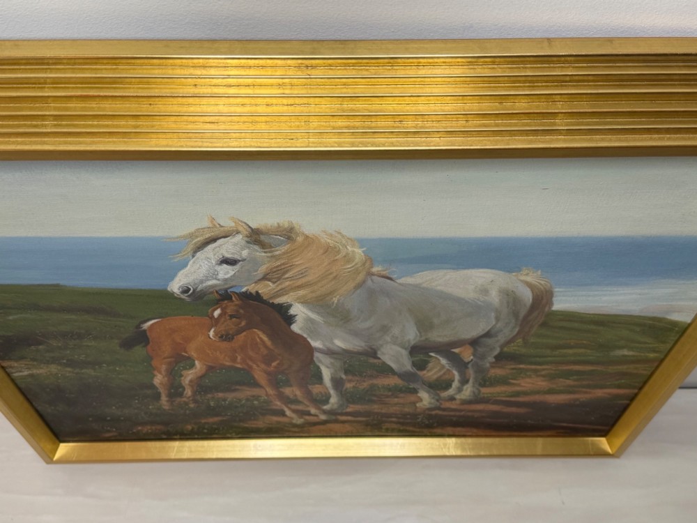 A framed oil painting featuring a grey mare standing beside a young chestnut foal on a grassy coastal headland overlooking the sea. View III