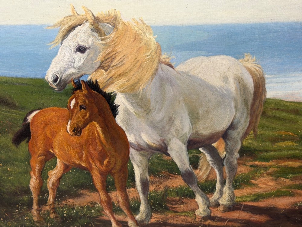 A framed oil painting featuring a grey mare standing beside a young chestnut foal on a grassy coastal headland overlooking the sea. View IX