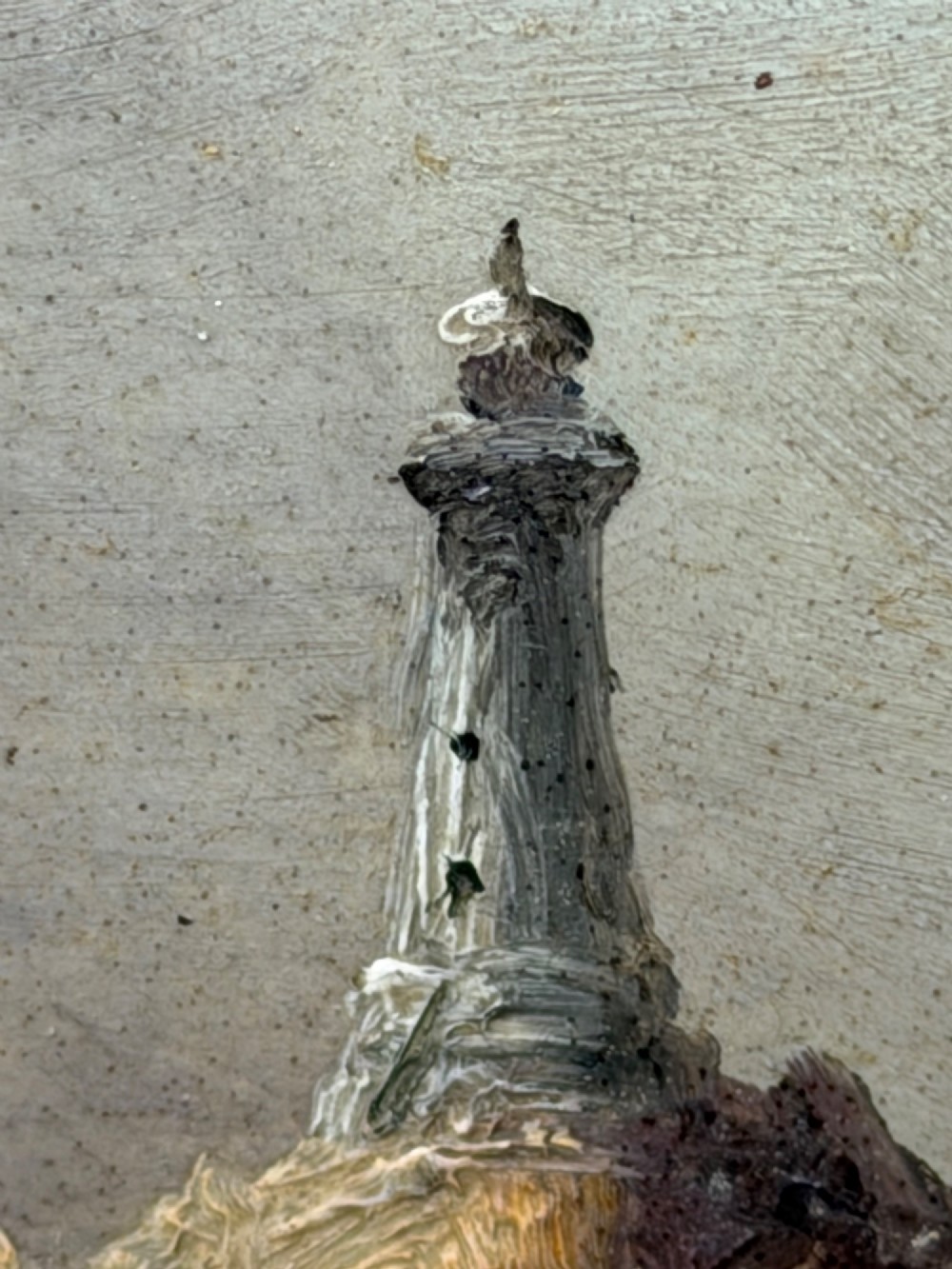 A vertical oil painting framed in carved gold leaf depicting La Corbiere lighthouse atop jagged rocks amidst a stormy grey sea with a shipwreck in the foreground. View XI
